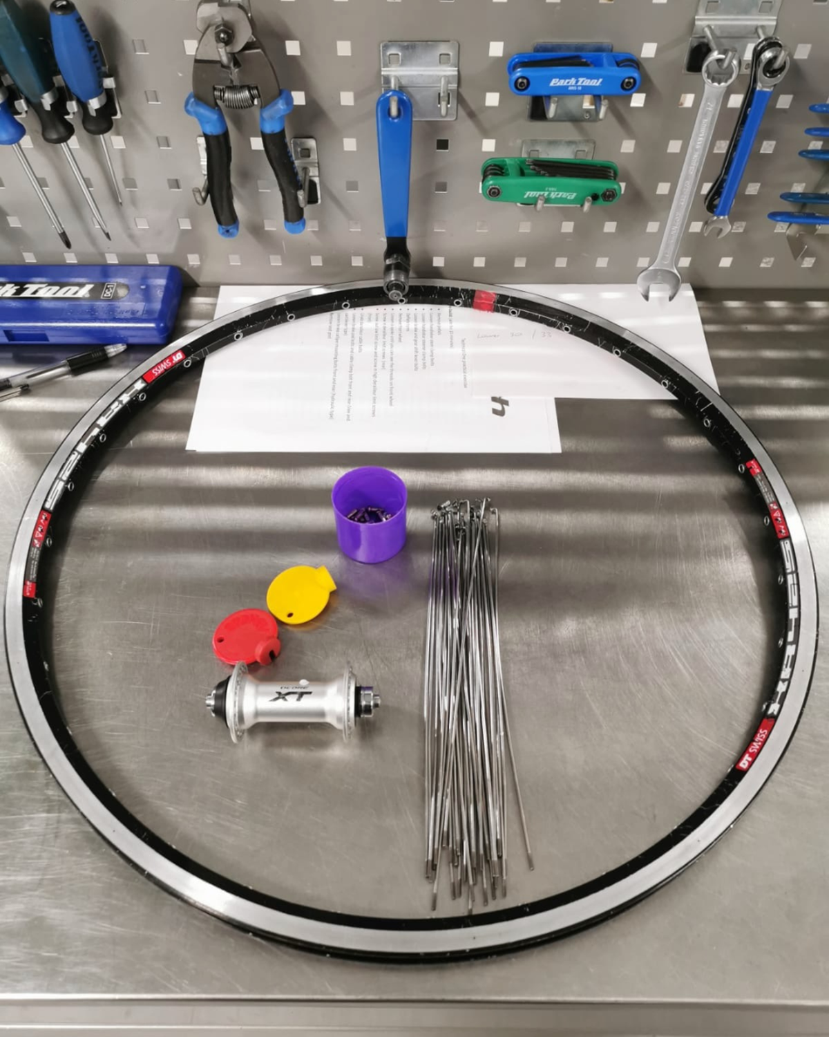 Hand-built wheels on the truing stand at the Aztecs Bikes workshop in Bow