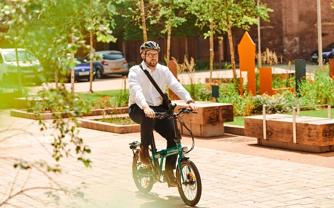 Commuter riding a Hygge Virum folding e-bike in British Racing Green through a London courtyard